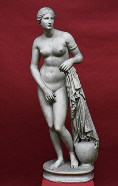 Marble statue of the goddess Aphrodite, nude, standing next to a pot and holding a garment in her left hand.